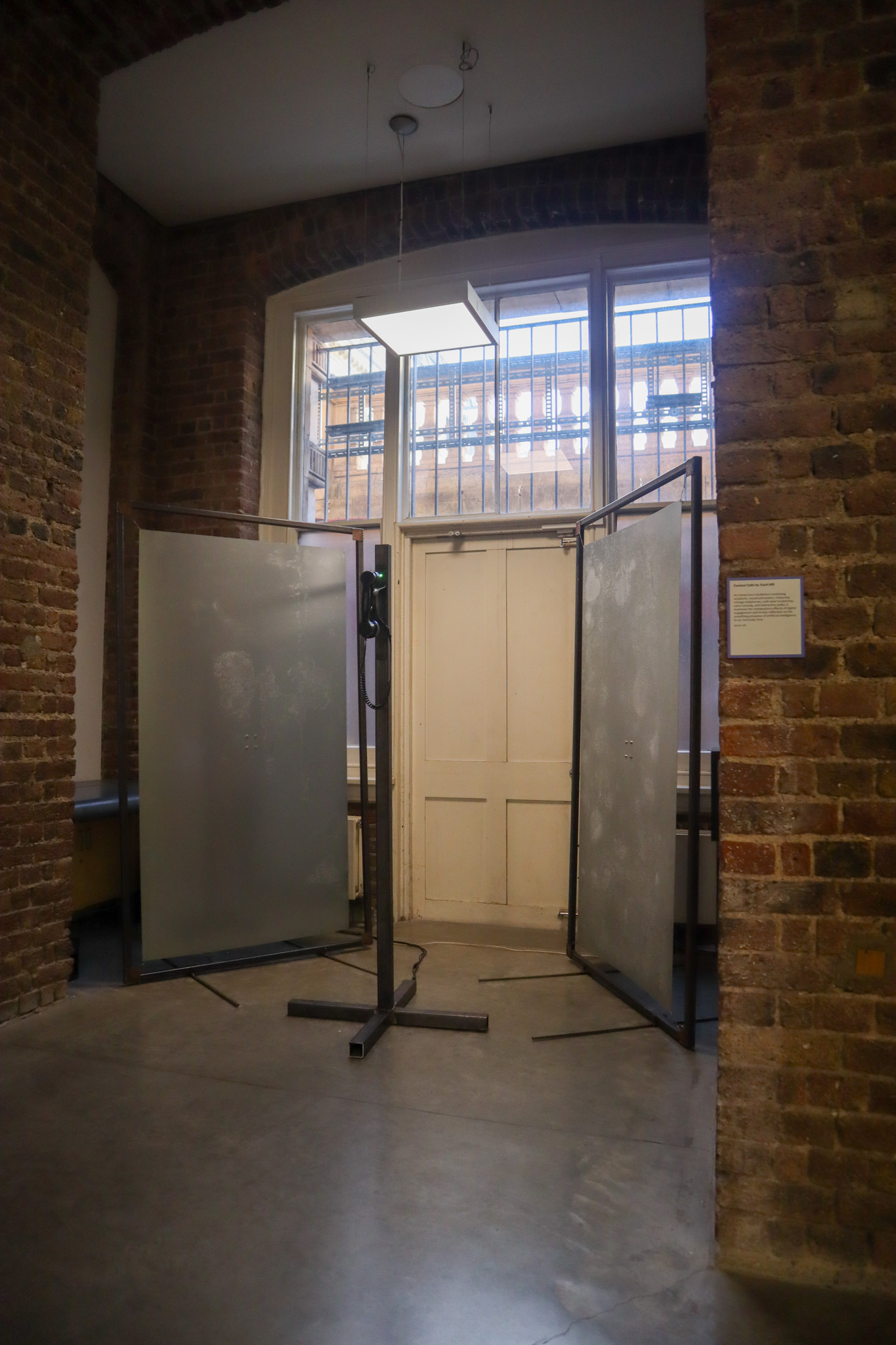 Phone on a metal pole with a red light ontop of it